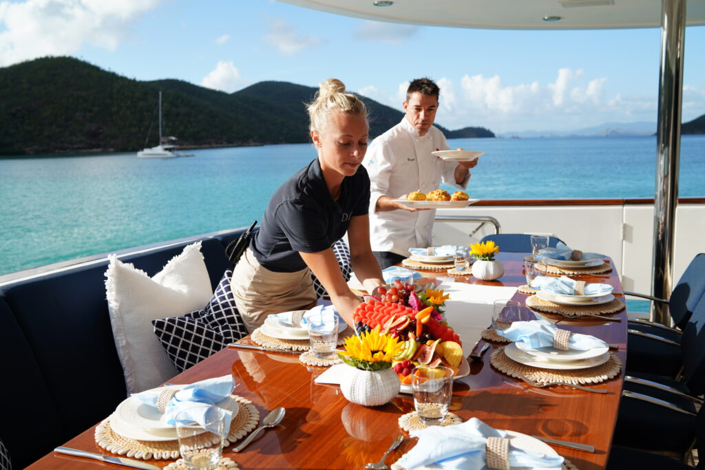 chief stewardess and head chef preparing and setting up for charter guest meal