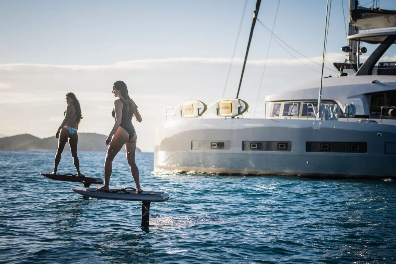 e foils board women infront of sailboat